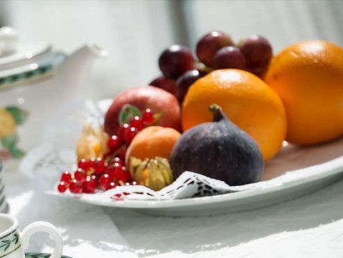 Arranged fruit plate with oranges, grapes, apricots, figs and currants